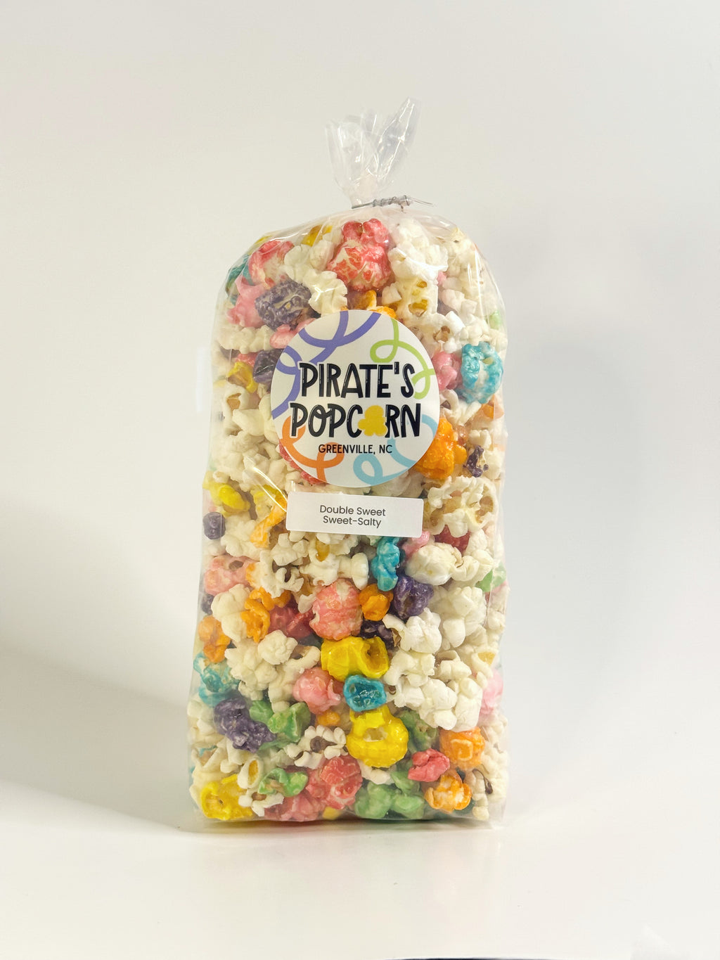 Bag of Pirate's Popcorn with colorful candy pieces on a white background