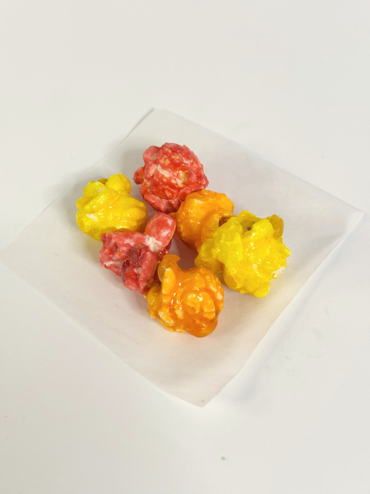 Colorful popcorn balls on a white plate with a white background