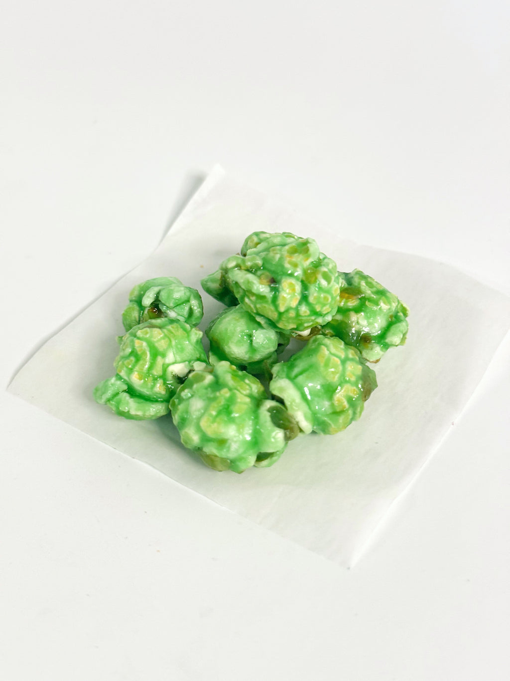Green popcorn on a white plate with a white background gourmet popcorn gift bag