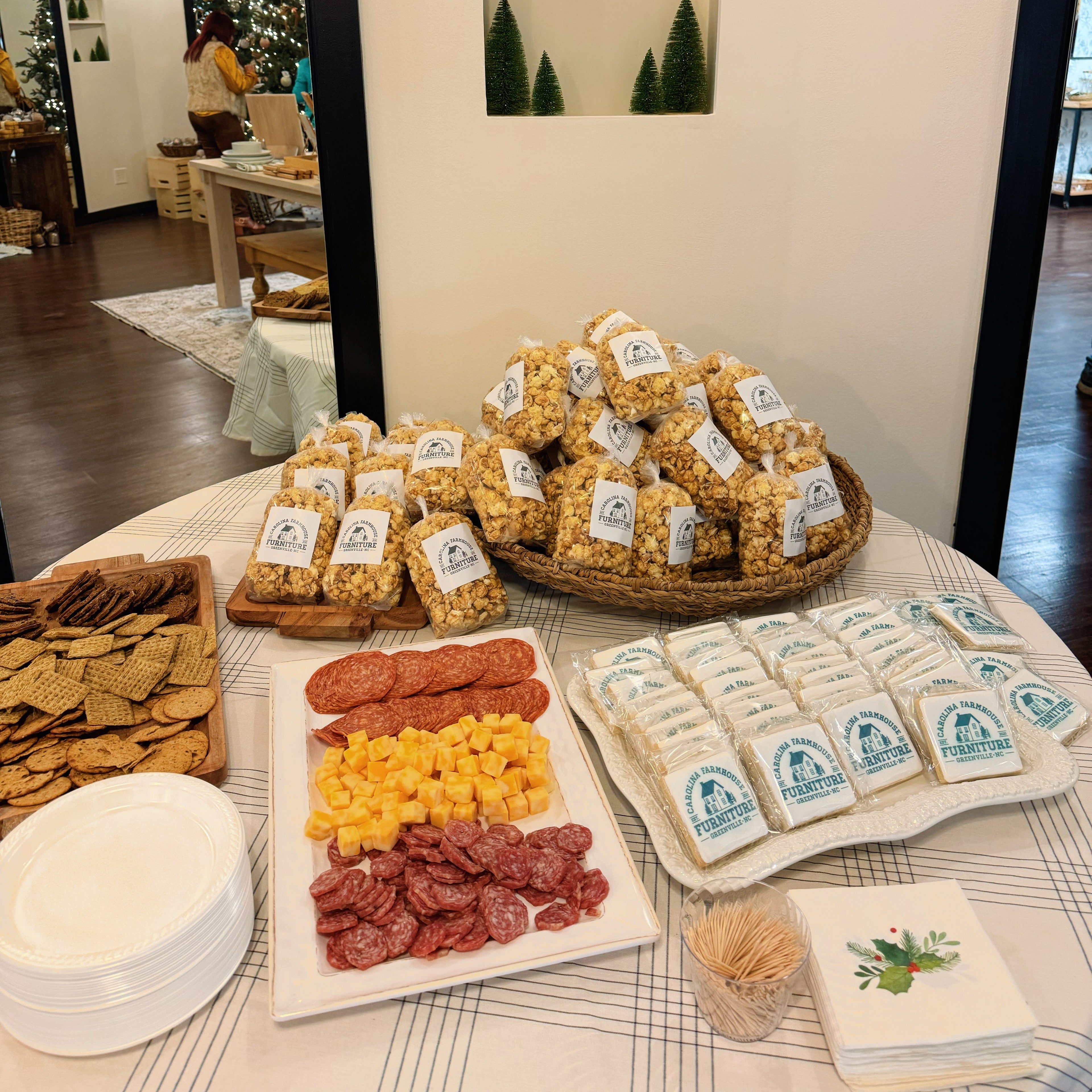 Table with assorted snacks including crackers, cheese, and meats in a room setting. popcorn catering