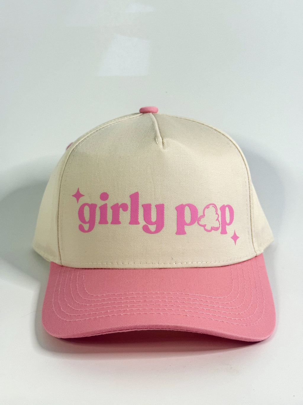 Beige and pink cap with 'girly pop' text on a light gray background