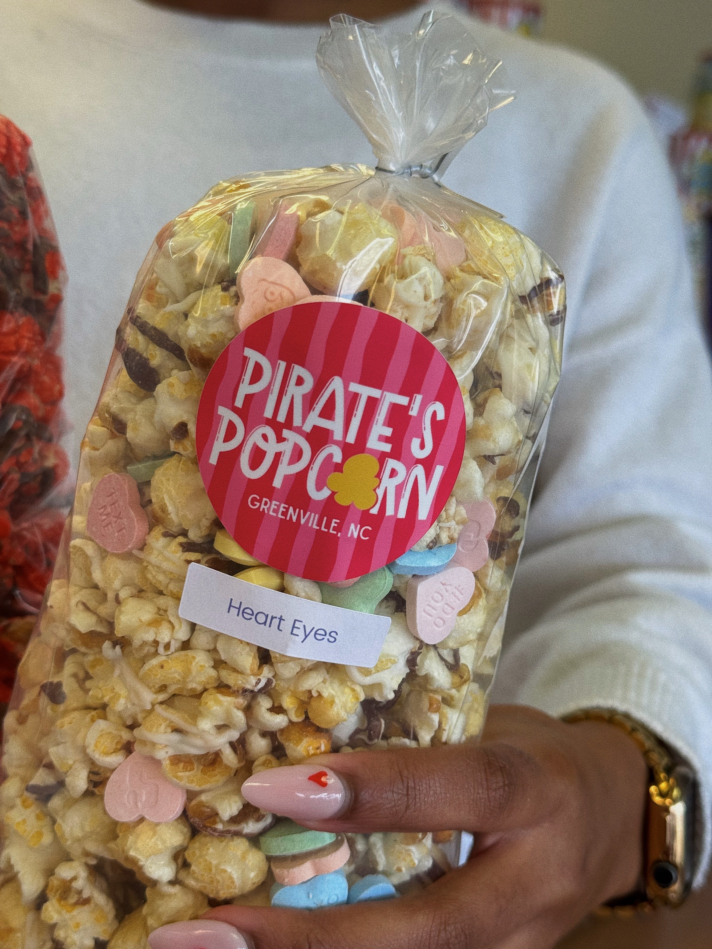 Pirate's Popcorn bag valentines gift with 'Heart Eyes' flavor held by a person