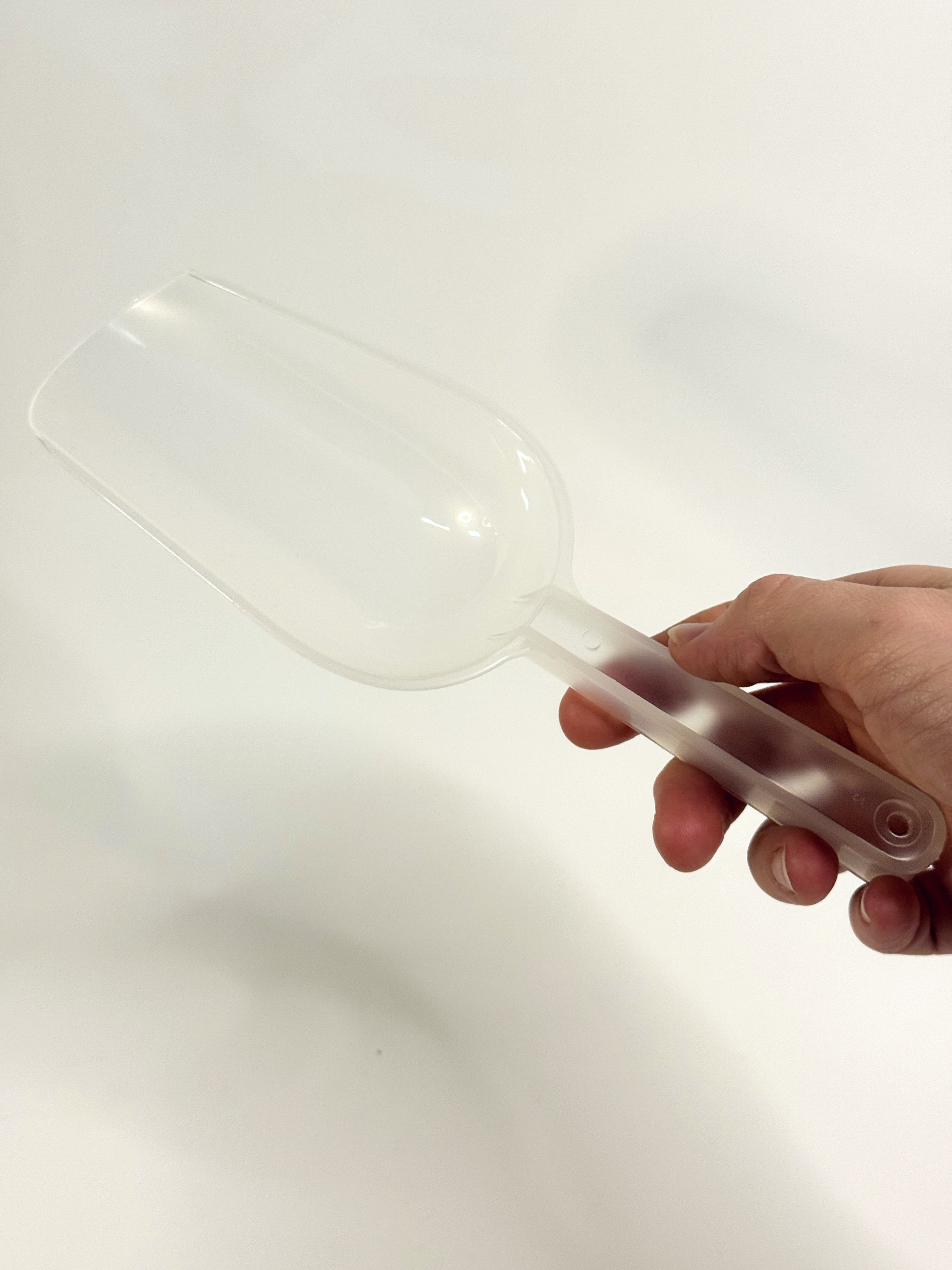 Clear plastic container held by a hand on a white background