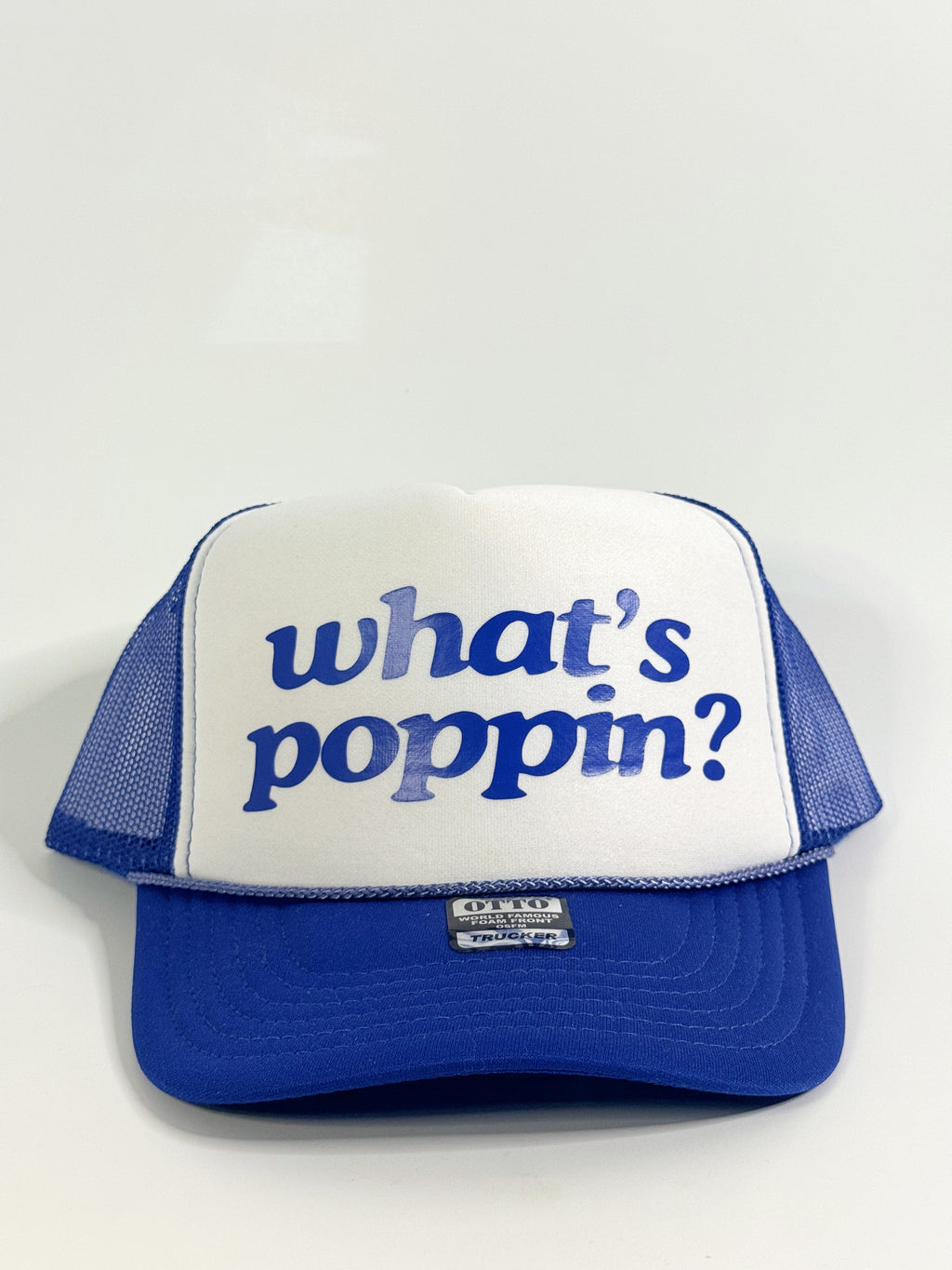 Blue and white cap with 'what's poppin?' text on a light gray background